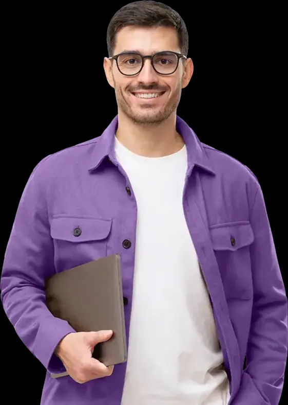 Mężczyzna w okularach z laptopem w ręku, uśmiechnięty w fioletowej kurtce.